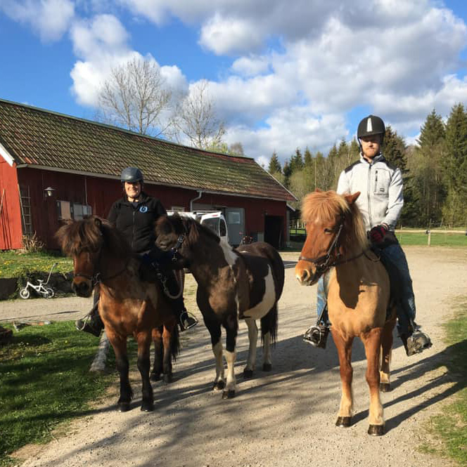 De tre hästarna står redo och två glada ryttare ler mot kameran.